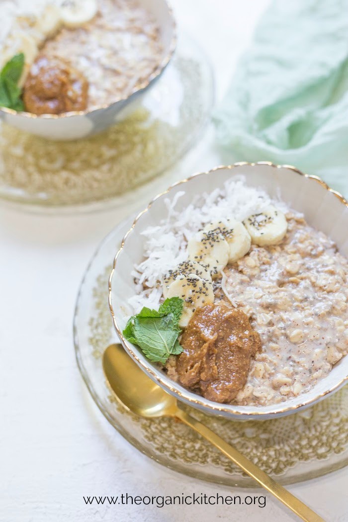 A bowl of Maple, Almond Butter and Banana Overnight Oats on gold laced saucer