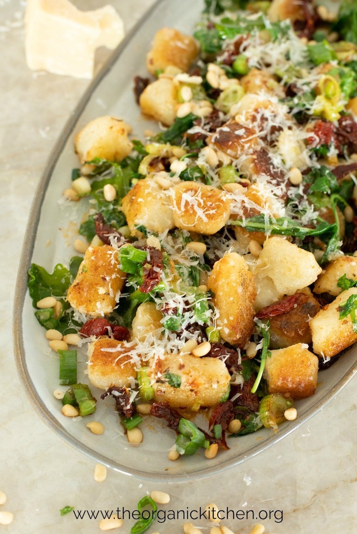 Gnocchi with Sun Dried Tomatoes and Baby Arugula garnished with freshly grated Parmesan