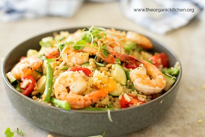 Lemony Shrimp and Vegetable Stir Fry Bowl on marble surface with blue and white dish towel in the background