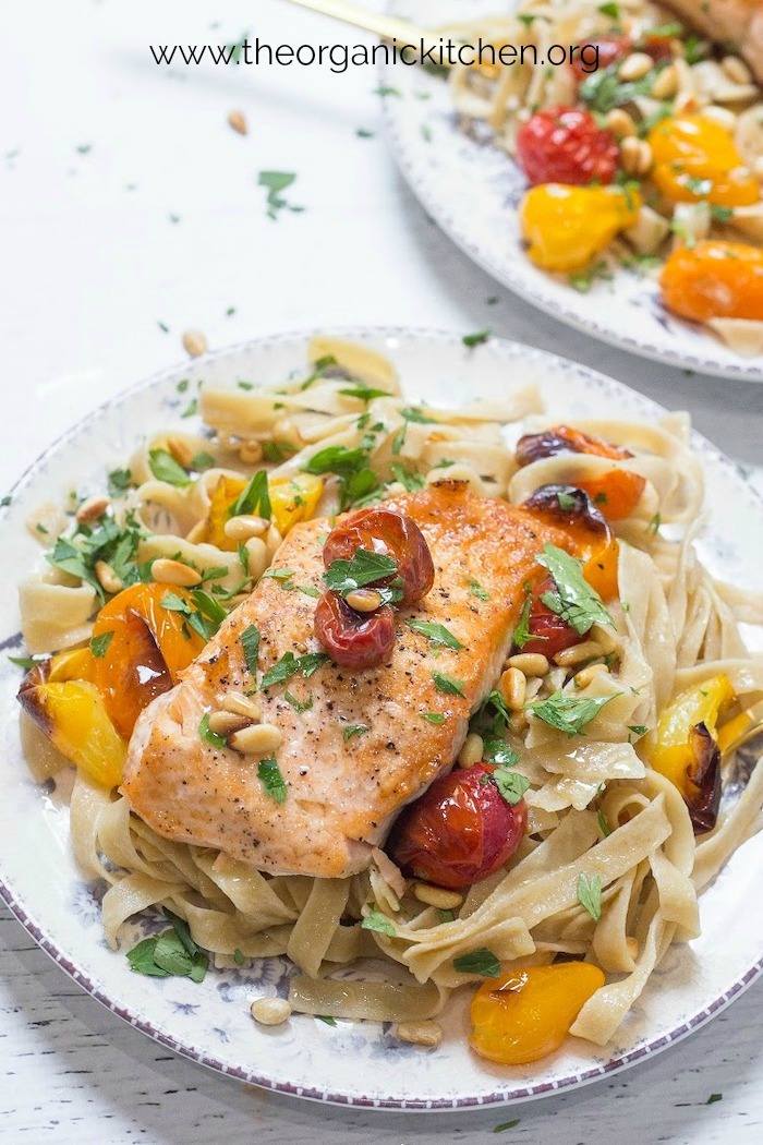 Two plates of Crispy Salmon with Blistered Tomatoes and Pasta on blue and white plates