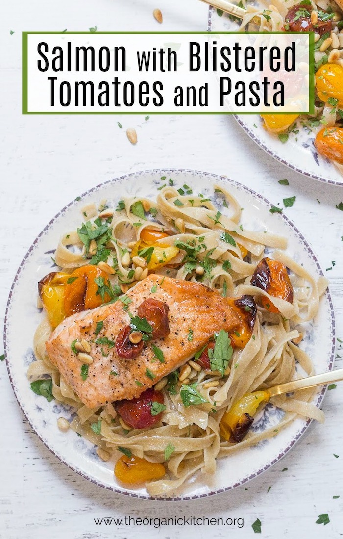 Apiece Crispy Salmon with Blistered Tomatoes and Pasta on a white plate set on a white background