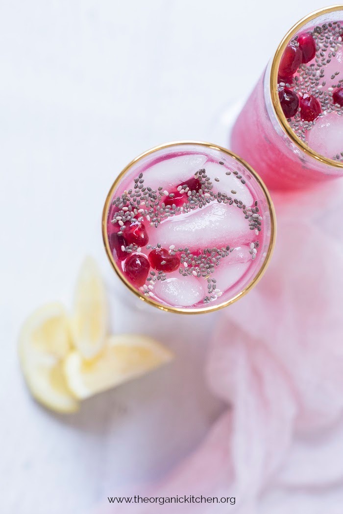 Two glasses of Low Carb Lemon Pomegranate Spritzer with Chia set on white table