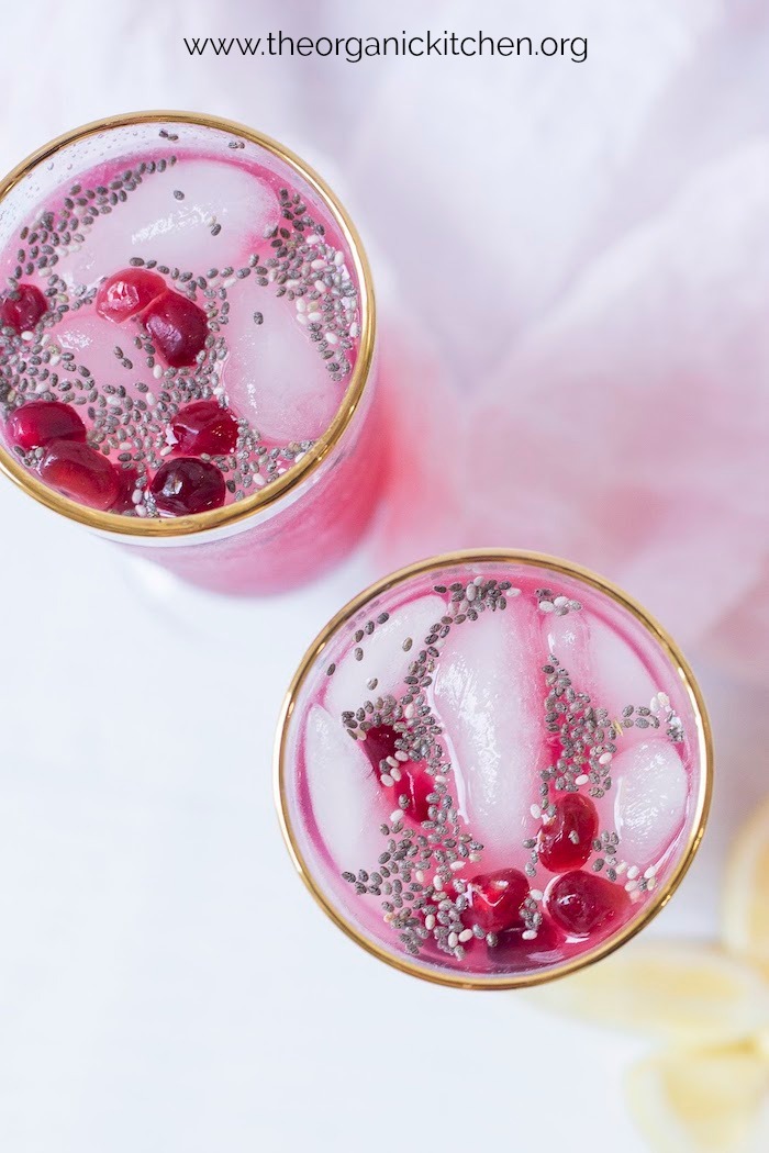 Two glasses with gold rims filled with Low Carb Lemon Pomegranate Spritzer with Chia!