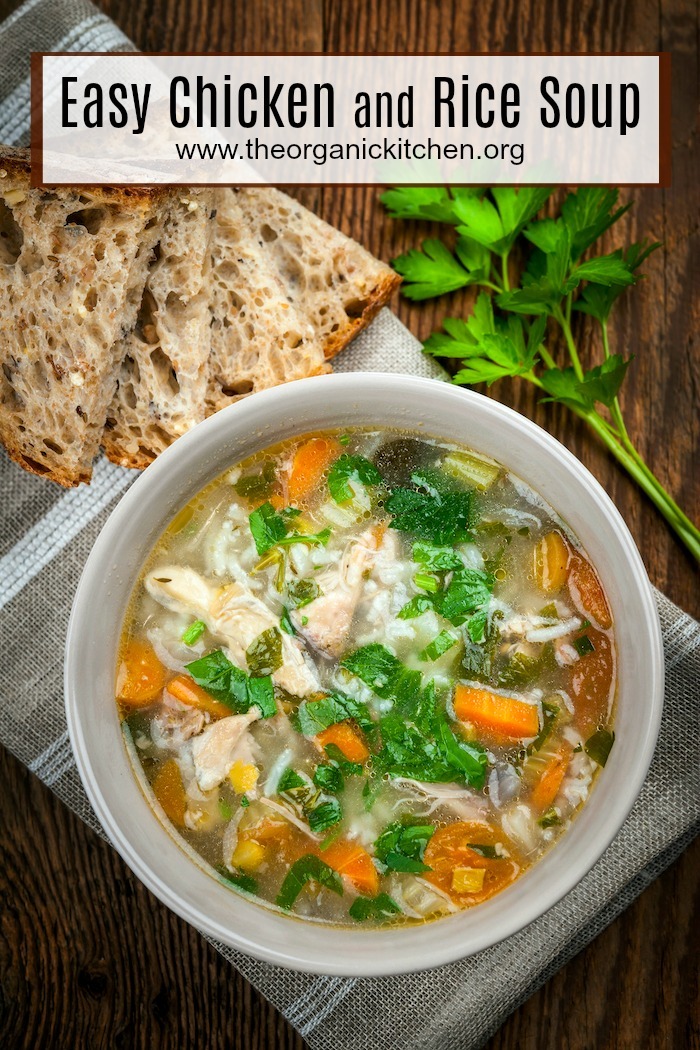 A white bowl of Easy Chicken and Rice Soup on a wooden table with three slices of bread