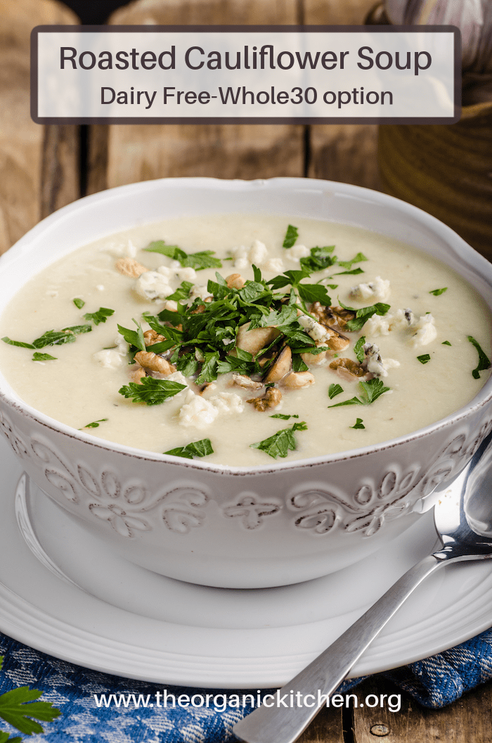 Roasted Cauliflower Soup (Whole30) garnished with parsley in white bowl with silver spoon