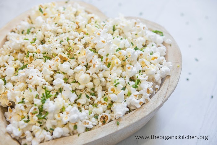 Parmesan Chive Popcorn in a wooden bowl on white surface