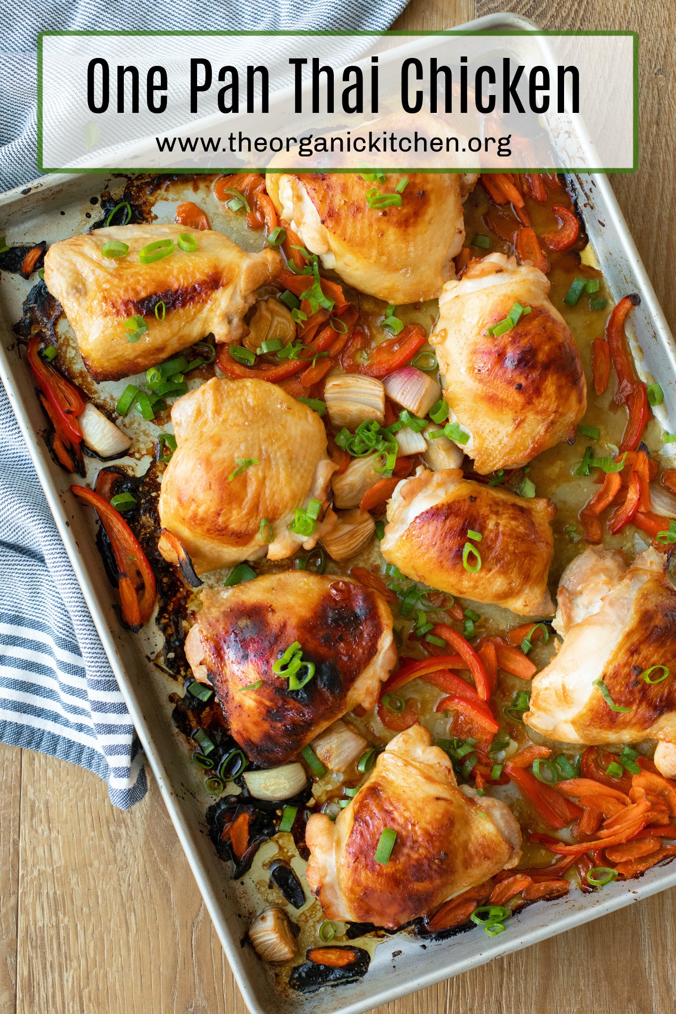 Golden One Pan Thai Chicken and vegetables garnished with green onions on a rimmed cookie sheet