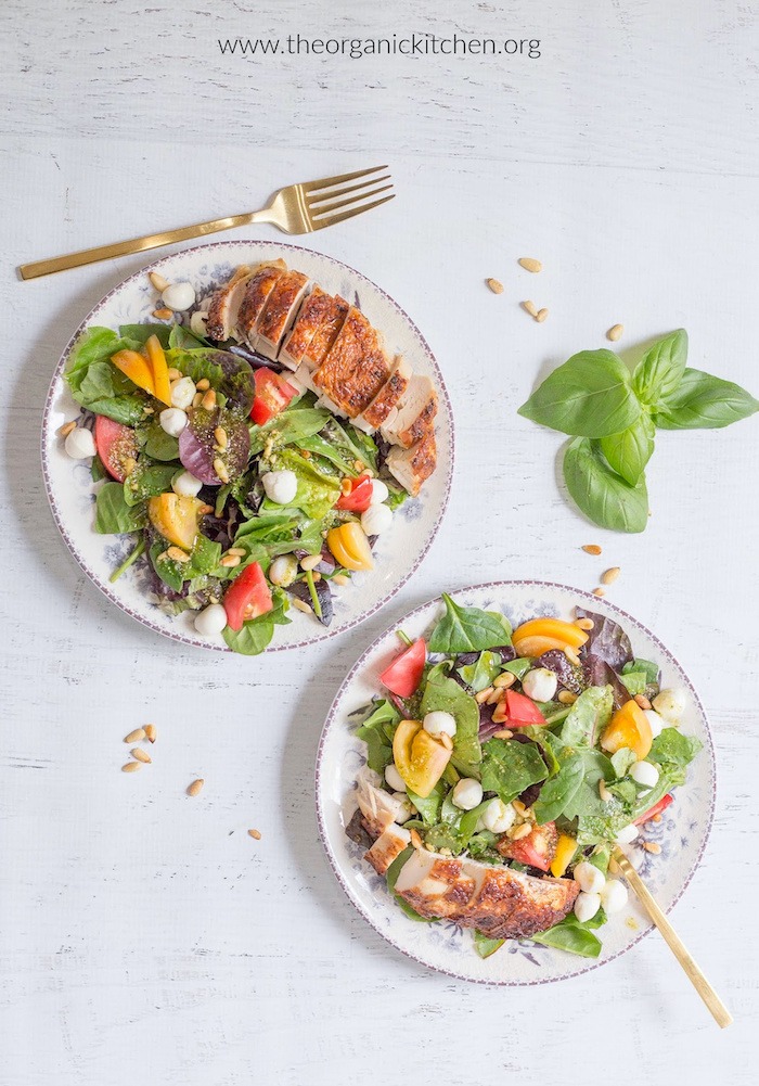 Easy Caprese Salad with Pesto Vinaigrette on two blue and white plates with gold forks