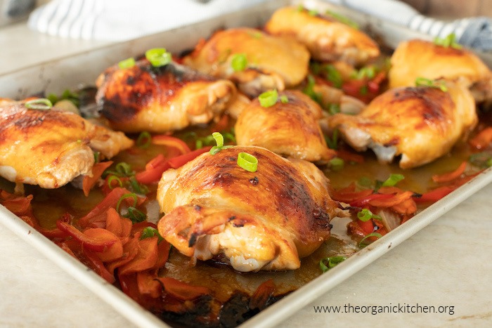 One Pan Thai Chicken with roasted veggies on rimmed cookie sheet on marble counter