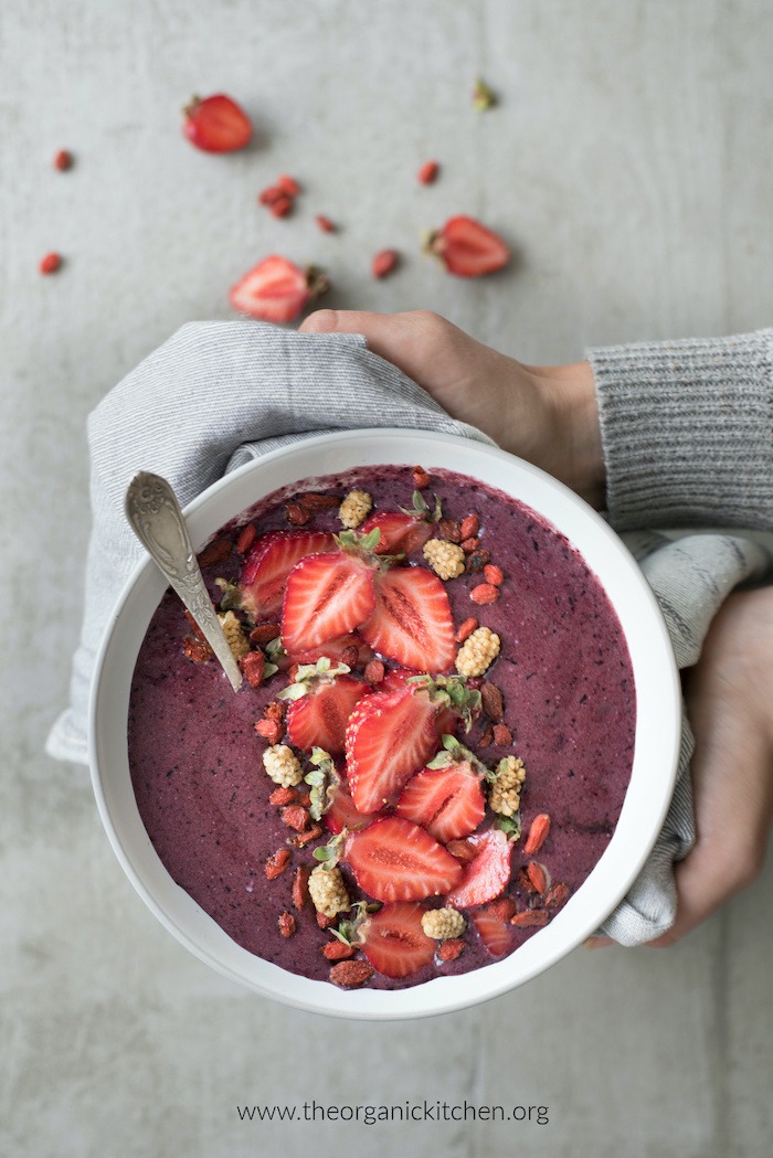 Healthy Açaí Smoothie Bowl with spoon being held by a woman's hands