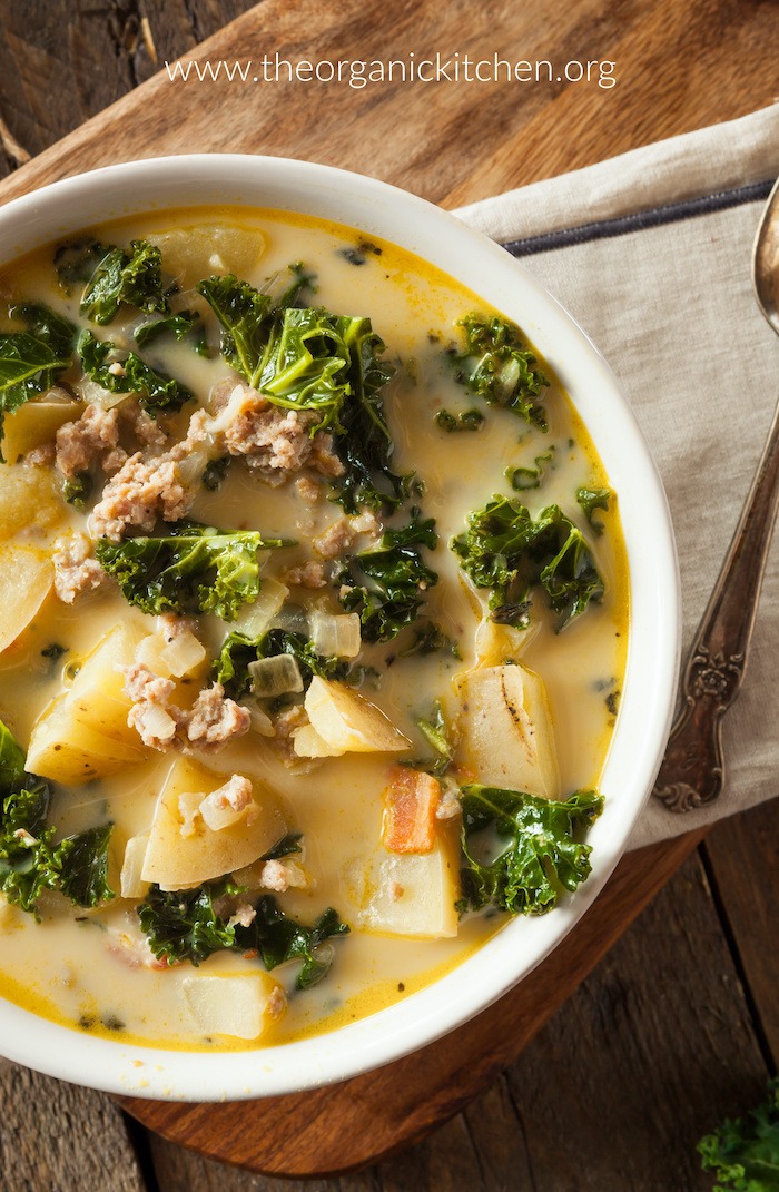 Zuppa Toscana (with Dairy free option) in a white bowl set on a wood serving board 