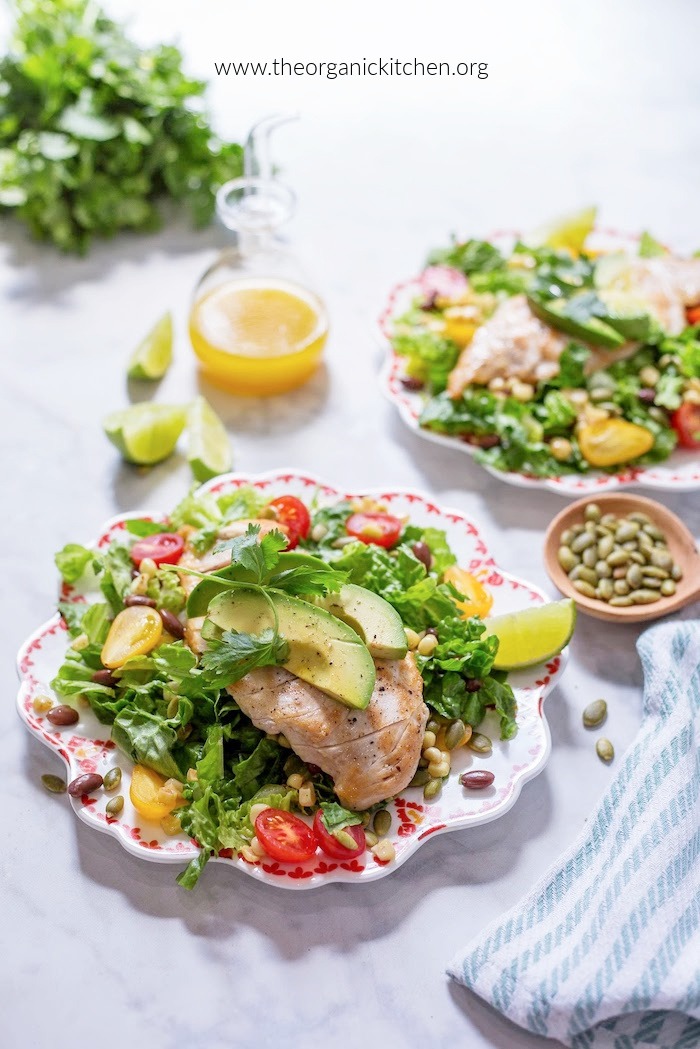 Southwest Chicken Salad with Citrus Vinaigrette with lime wedges, avocado and pumpkin seeds