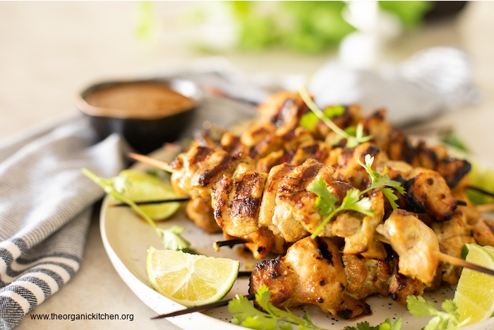 Chicken Satay with Sweet and Spicy Sauce garnished with lime and cilantro