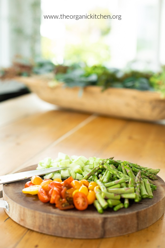 Ingredients for Pasta Salad with Greens and Asparagus on a cutting board