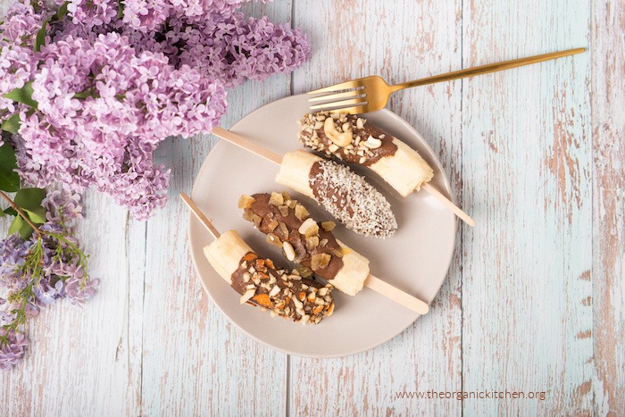 Chocolate Dipped Frozen Bananas with gold fork on white plate