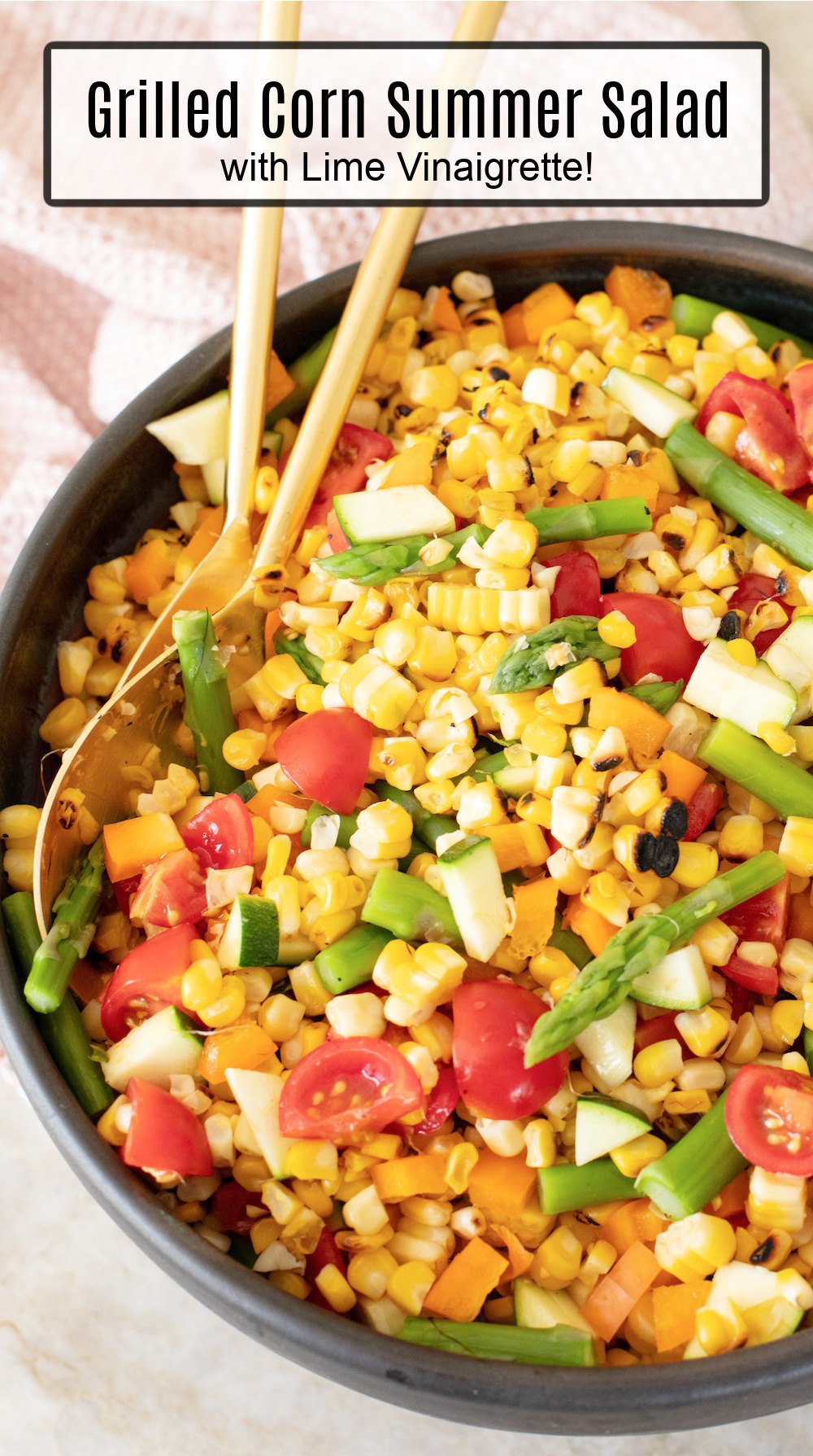 Grilled Corn Summer Salad in black bowl with gold serving spoons