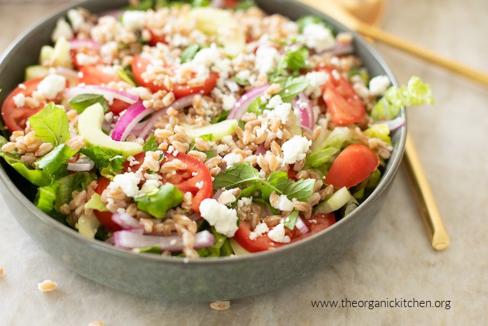 Chopped Greek salad in grey bowl on marble surface