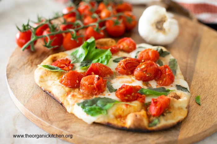 Grilled Naan Margherita Pizza on a wooden cutting board