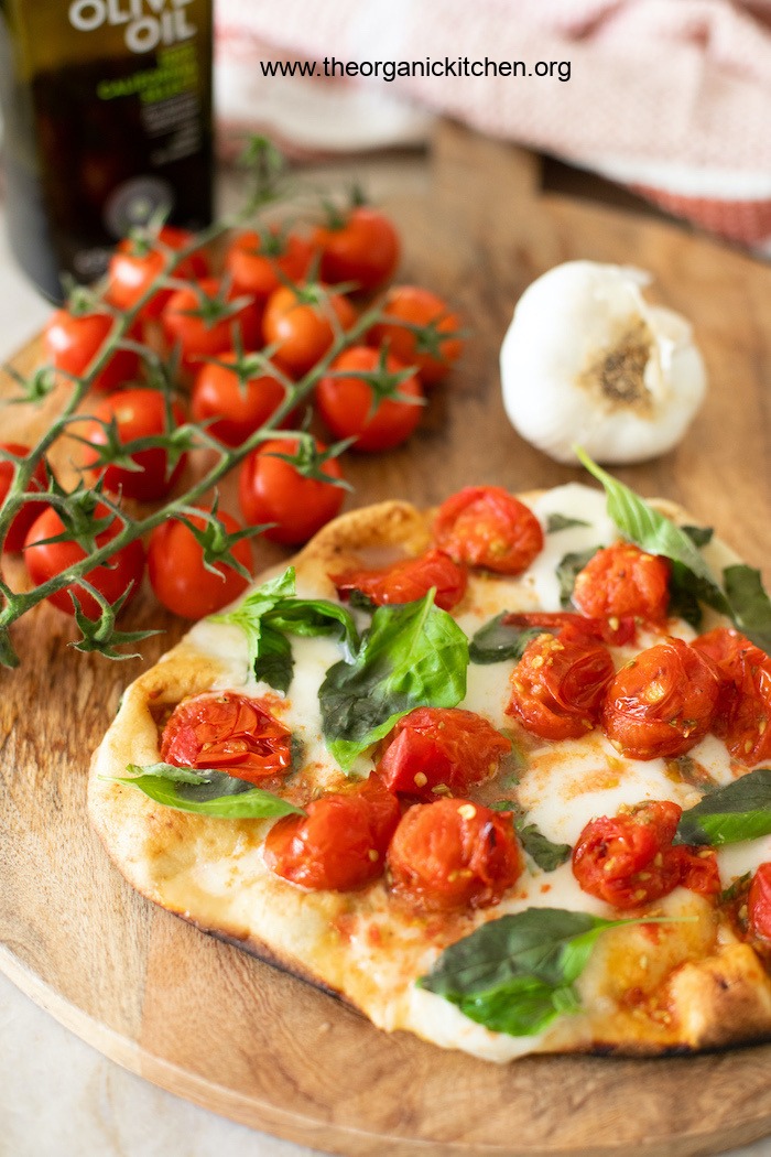 A freshly baked Grilled Naan Margherita Pizza on a wooden serving board