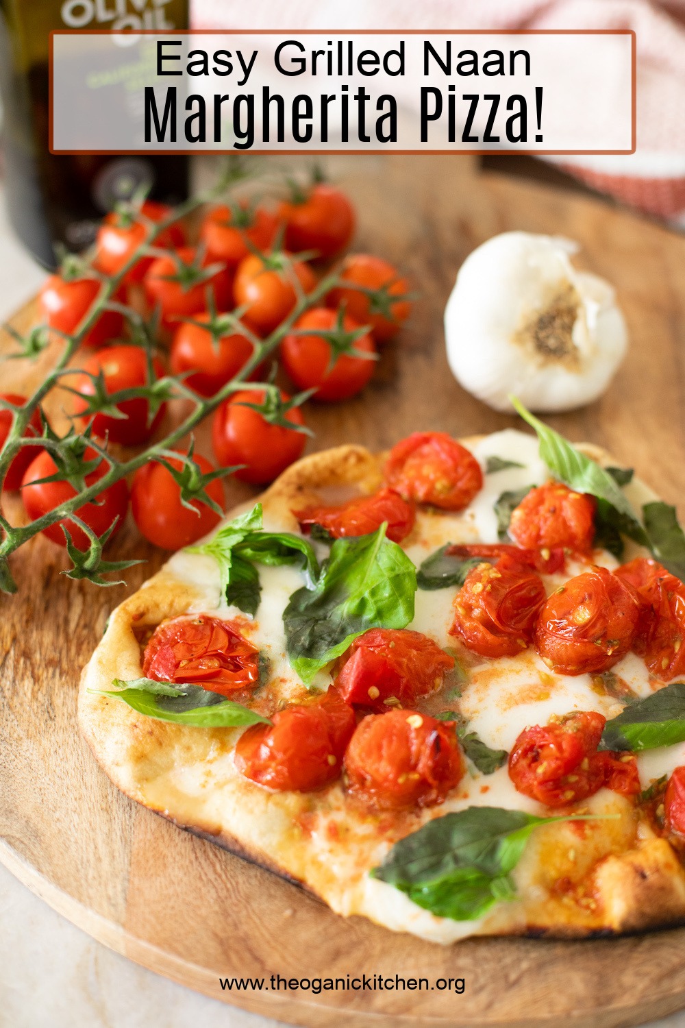 A Grilled Naan Margherita Pizza on a cutting board surrounded by tomatoes and garlic