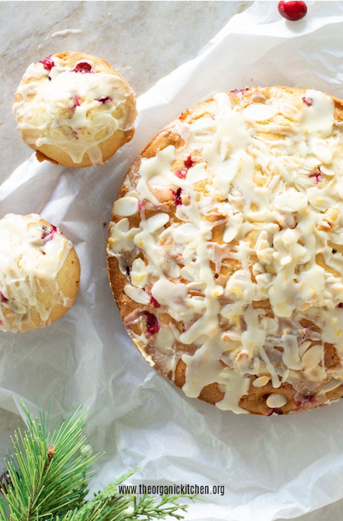 Orange Cranberry Cake and Muffins on white parchment with cranberries