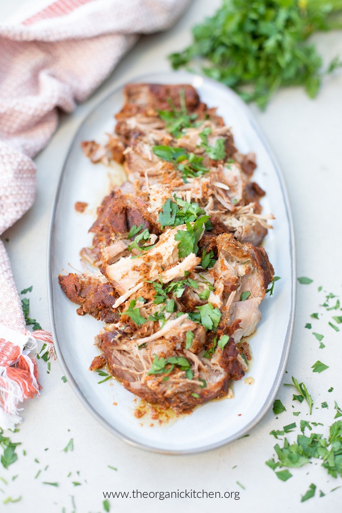 Whole30 Spice Rubbed Pork Roast and juices on gray platter set on a cement table