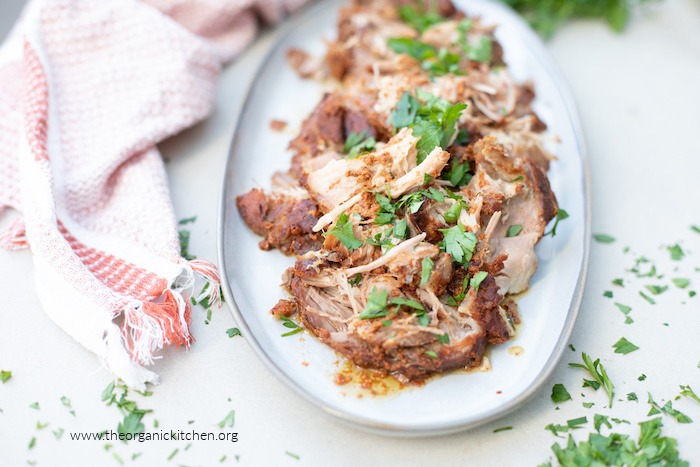 Pulled pork on white platter garnished with parsley