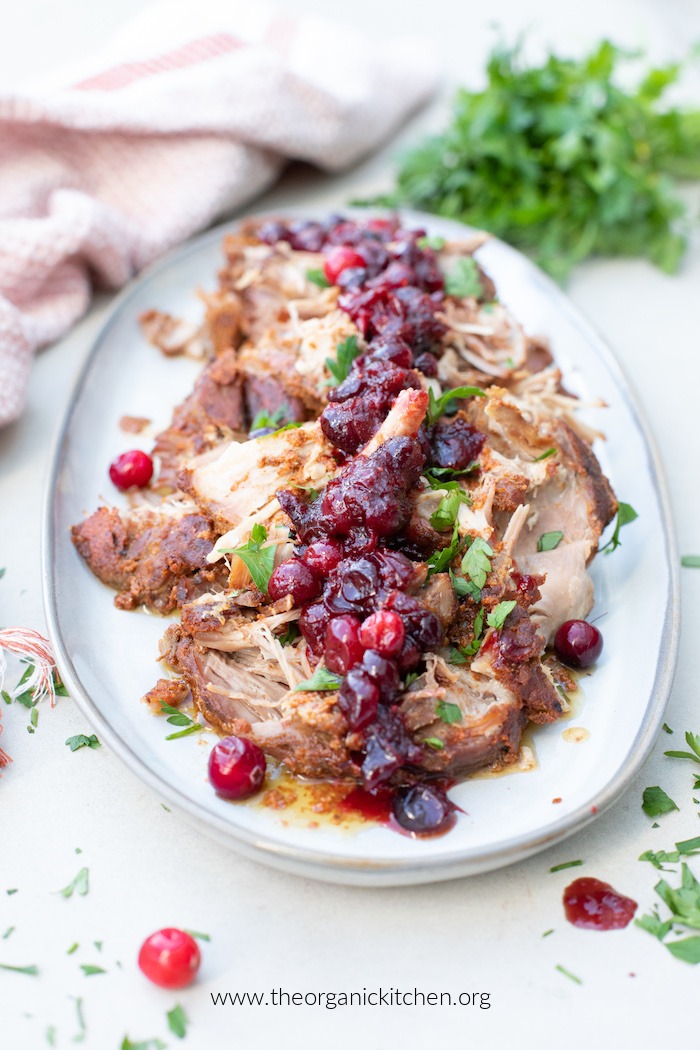 Holiday Pork Roast with Cranberry Sauce garnished with fresh cranberries and herbs