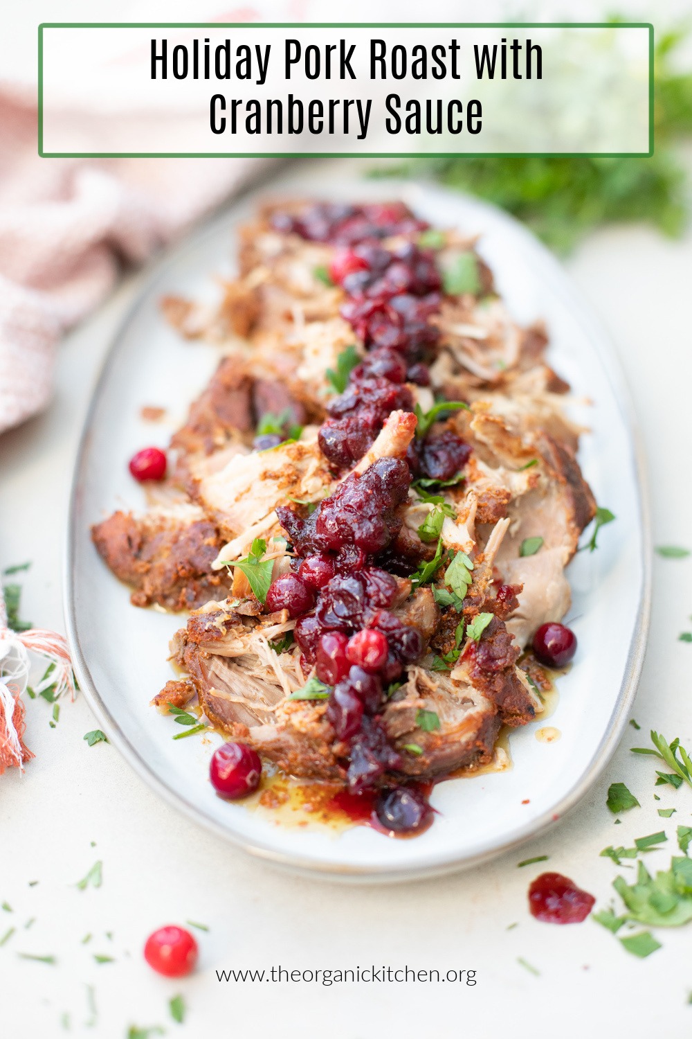Holiday Pork Roast with Cranberry Sauce on a grey plate and garnished with parsley