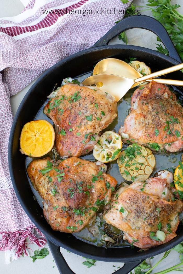 Easy Roasted Herb Butter Turkey Thighs in black skillet with gold serving spoons