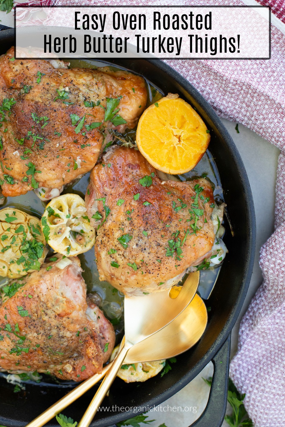 Easy Roasted Herb Butter Turkey Thighs in black skillet with lemon and garlic halves 