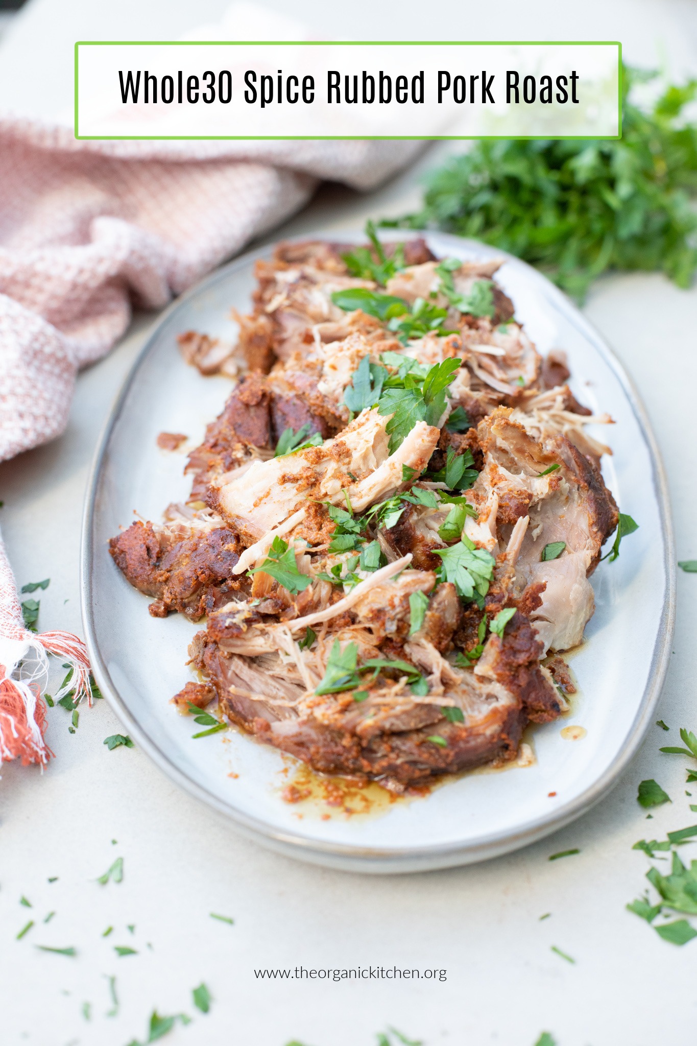 Whole30 Spice Rubbed Pork Roast garnished with parsley on white platter