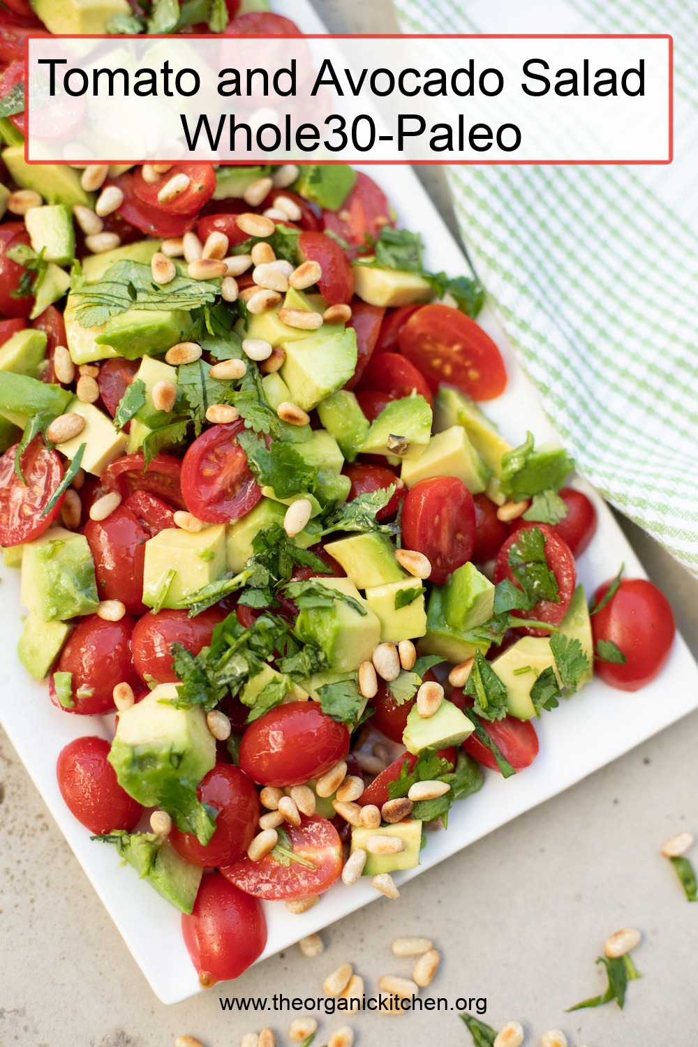 Tomato and Avocado Salad (Whole30) garnished with cilantro and pine nuts on white plate