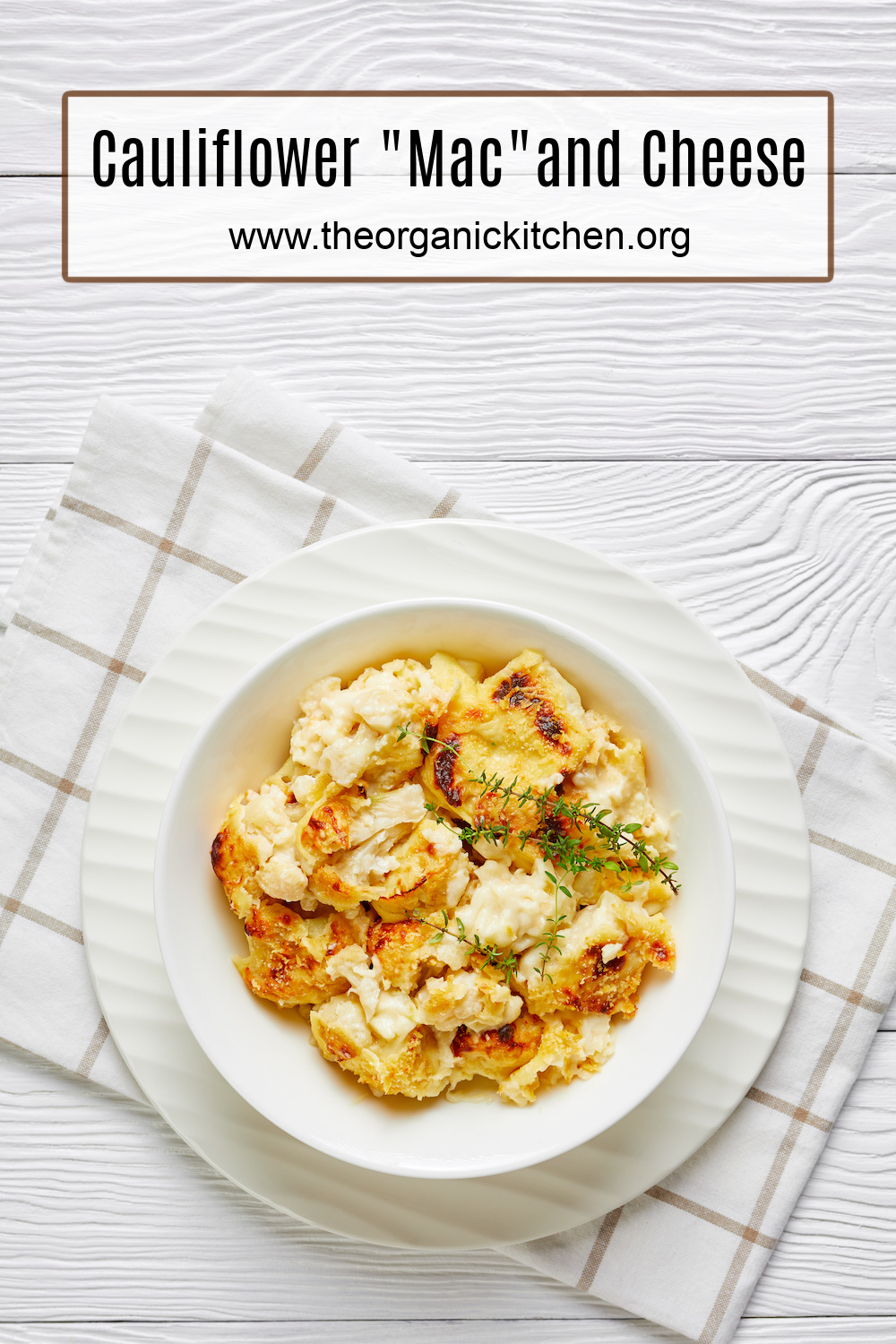 Cauliflower "Mac" and Cheese on white plate set atop brown and white plaid dish towel