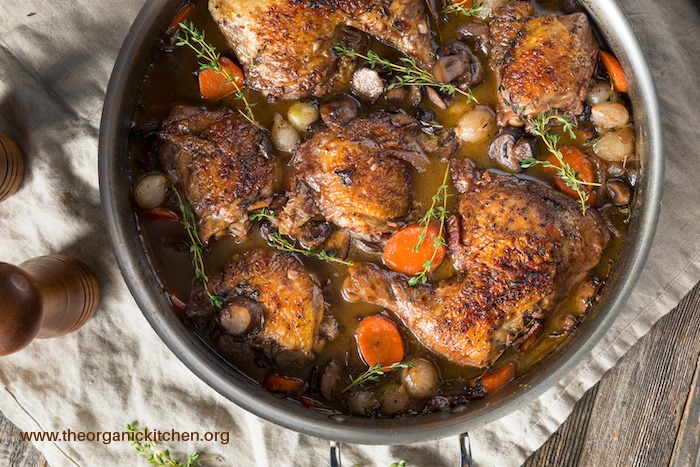 Homemade French Coq Au Vin Chicken with Veggies and Sauce in a stock poy set on white cloth