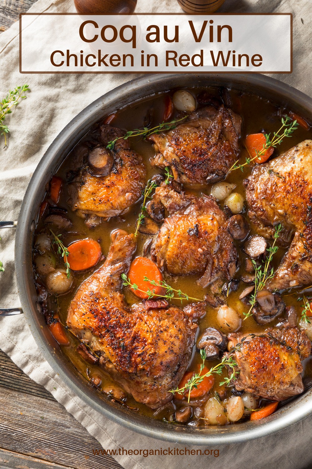 Coq Au Vin (Chicken in Red Wine) in a Dutch oven set on a white dish towel