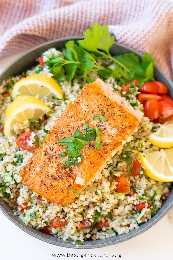 Salmon Tabbouleh Bowl on white surface with dish towel 
