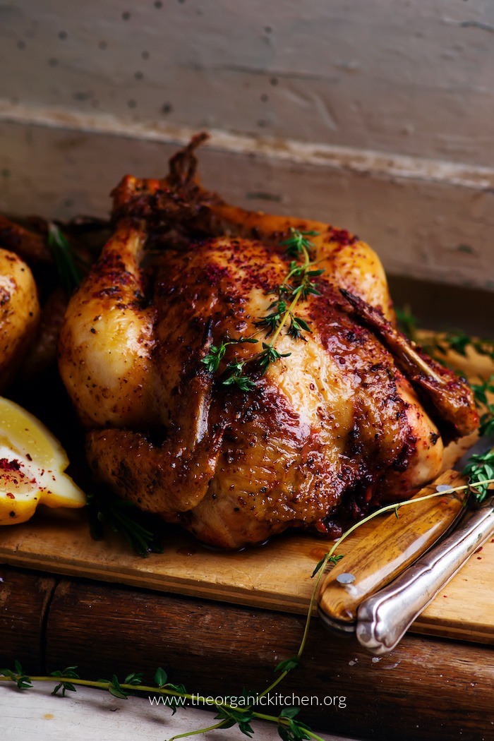 Easy Roast Chicken- Whole30/Keto on a wooden cutting board with rustic plaster wall in background