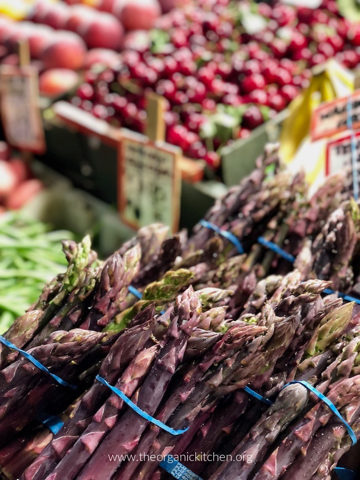 12 Helpful Farmers Market Tips! Colorful grapes, peaches and asparagus on a farmers market shelf