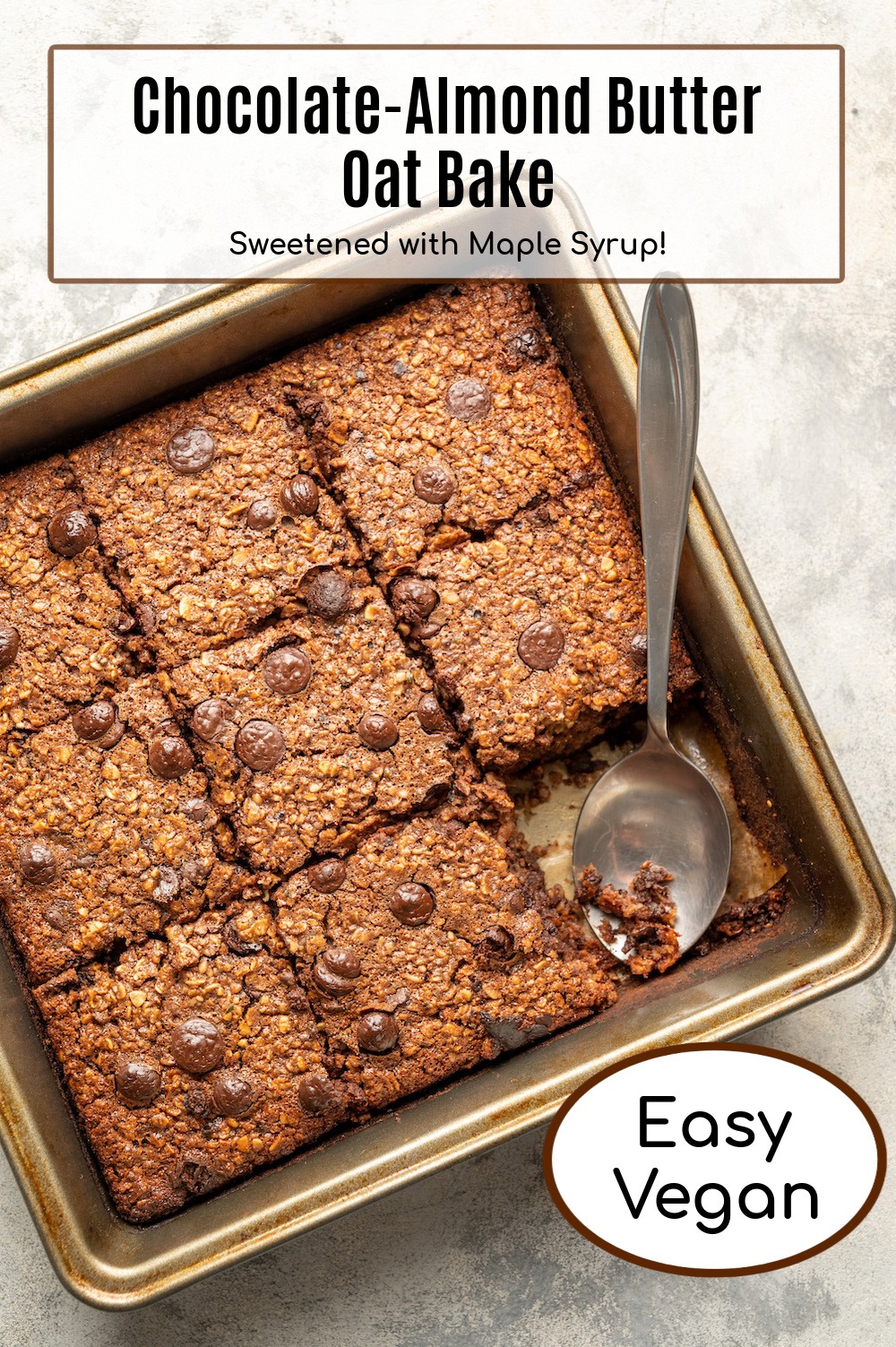 Vegan Chocolate Almond Butter Oat Bake cut into squares in metal baking dish with silver spoon
