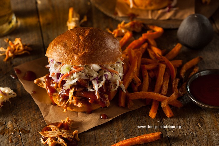 Crock Pot or Instant Pot BBQ Pulled Pork Sandwiches with sweet potato fries on parchment paper