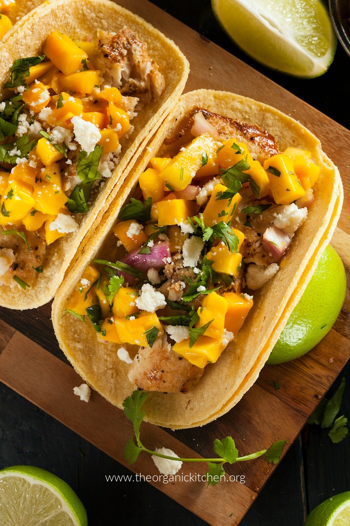 50+ Taco, Tostada and Fajita Recipes! Fish Tacos with Mango Salsa on wood plate as part of 50+ Taco, Tostada and Fajita Recipes!
