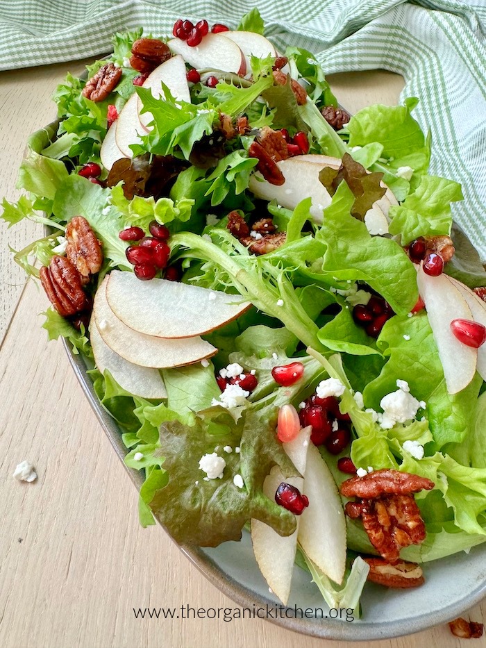 Pear and Pomegranate Winter Salad Pear and Pomegranate Winter Salad on gray plate set on wood surface with dish towel in the background
