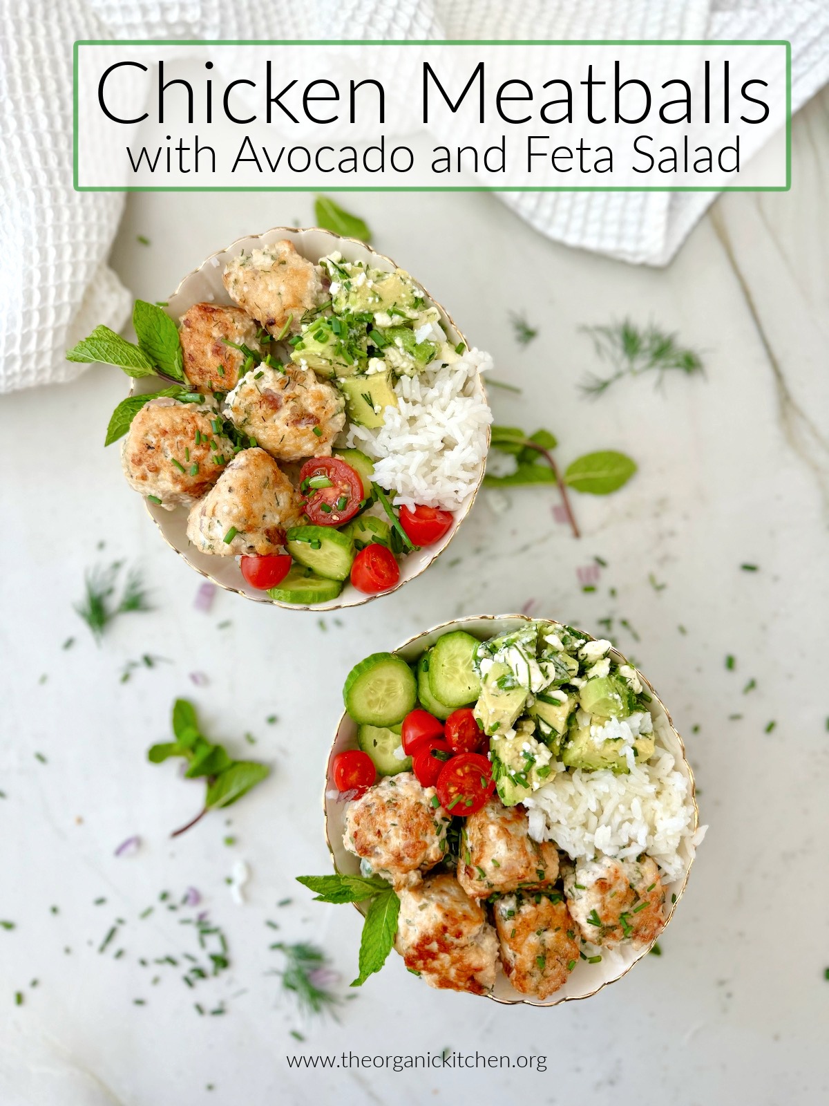 Chicken Meatballs with Avocado and Feta Salad in two bowls on marble surface, surrounded by herbs