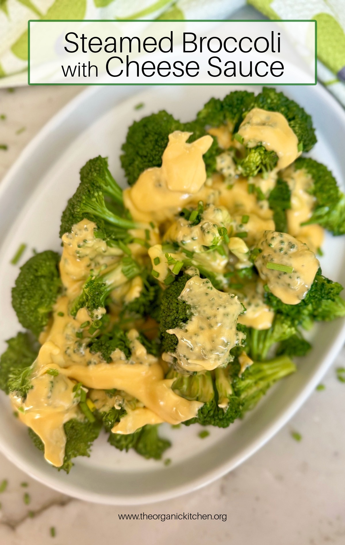 Steamed Broccoli with Cheese Sauce on white plate set on marble table