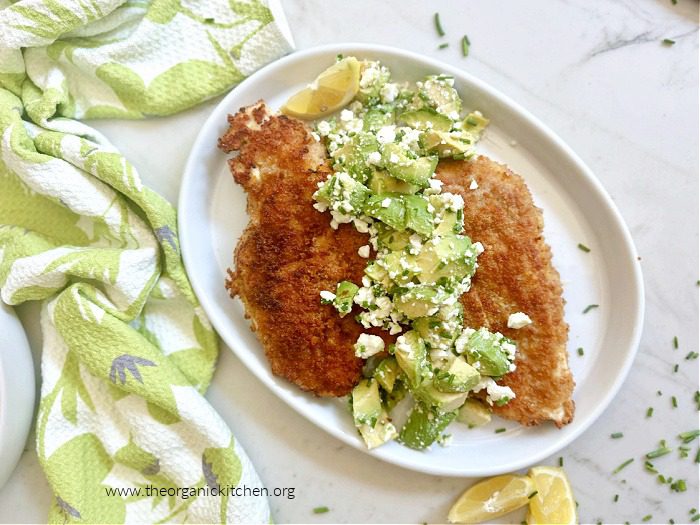 Crispy Chicken with Avocado and Feta Salad Crispy Chicken with Avocado and Feta Salad on white plate set on white marble surface with chives and lemon wedges