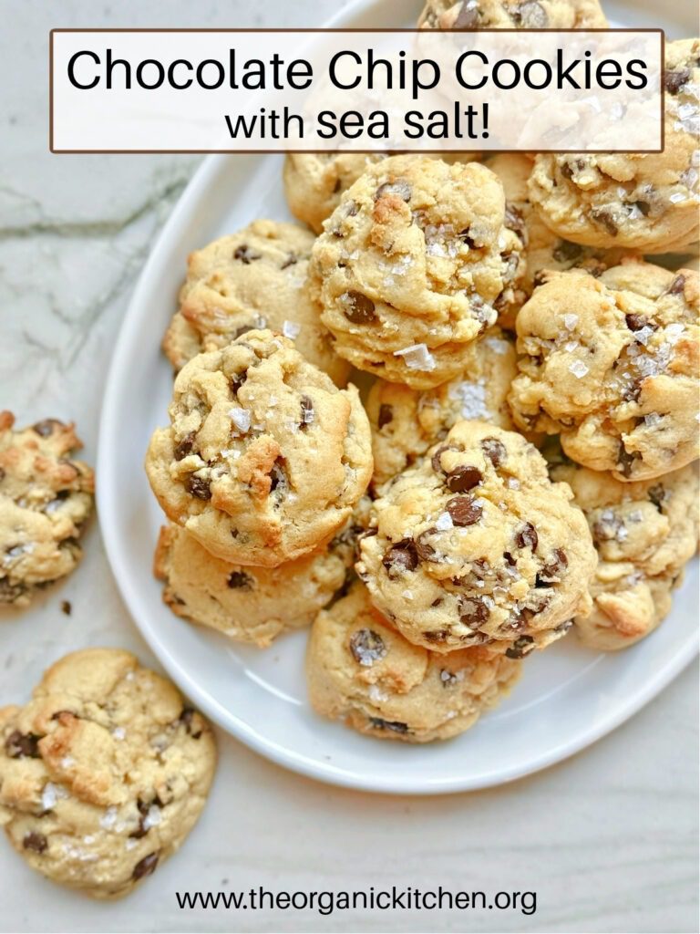 Twelve Delicious Chocolate Desserts! A white plate piled with chocolate chip cookies sprinkled with sea salt