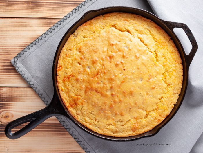 Cornbread in a black skillet on grey napkin 
