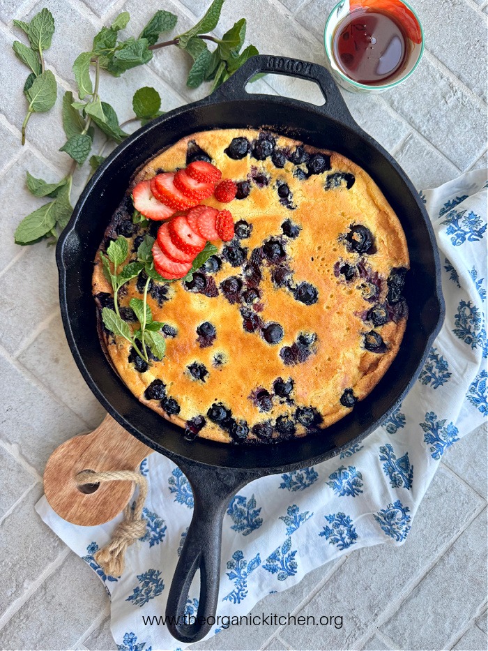 Lemon Blueberry Dutch Baby (No Refined Sugar!) topped with berries and mint in black skillet