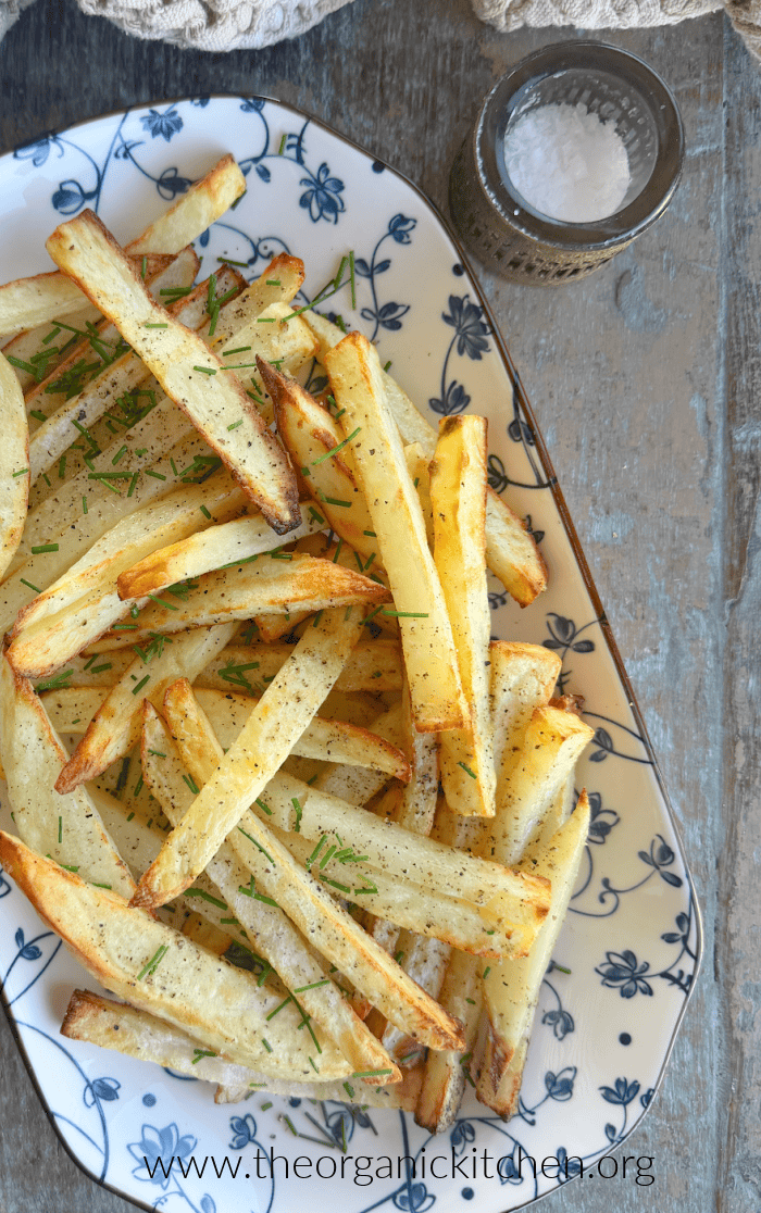 Air fryer French Fries Air fryer French Fries garnished with chives on blue and white plate on blue table